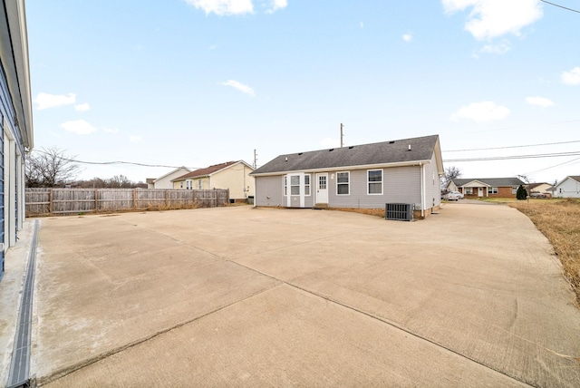 rear view of property with cooling unit, a patio, and fence