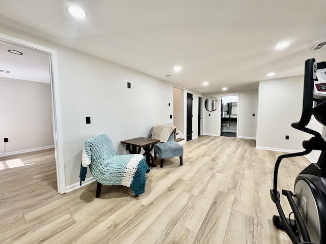 living area with baseboards, light wood-style flooring, and recessed lighting