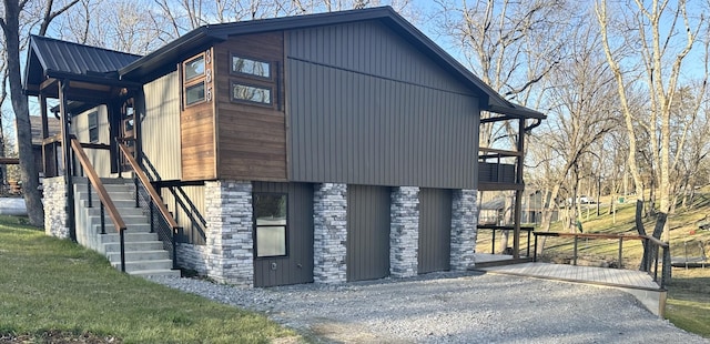 view of home's exterior featuring stone siding, metal roof, and a lawn