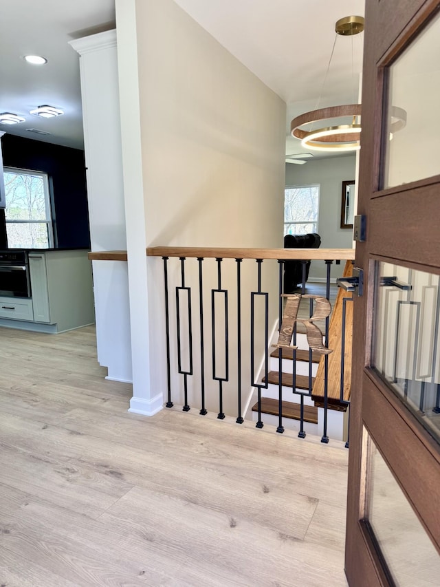 stairway with plenty of natural light, baseboards, and wood finished floors