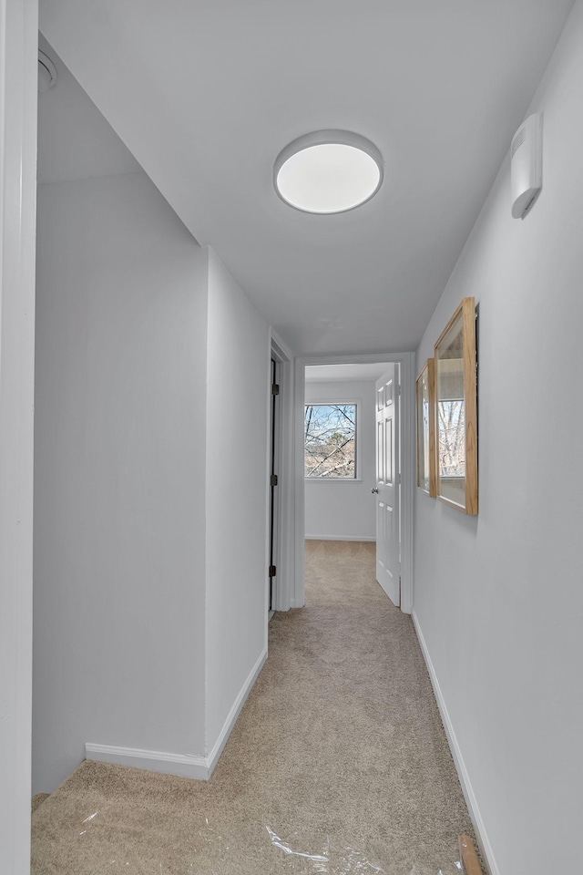 hallway with carpet floors and baseboards