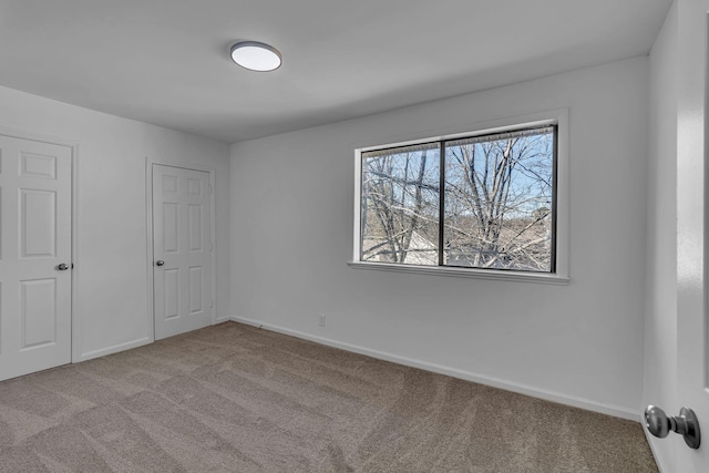 unfurnished bedroom featuring carpet floors and baseboards