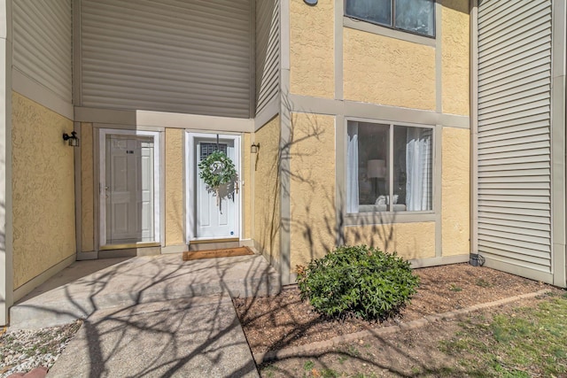 doorway to property featuring stucco siding