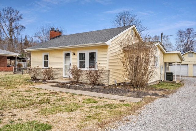 view of front of home featuring a shingled roof, a chimney, and a garage