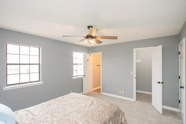 bedroom with baseboards, a ceiling fan, and light colored carpet