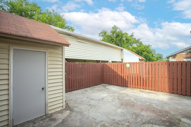 view of patio with fence and an outbuilding