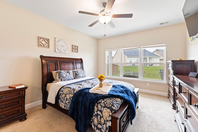 bedroom with baseboards, visible vents, a ceiling fan, and light colored carpet