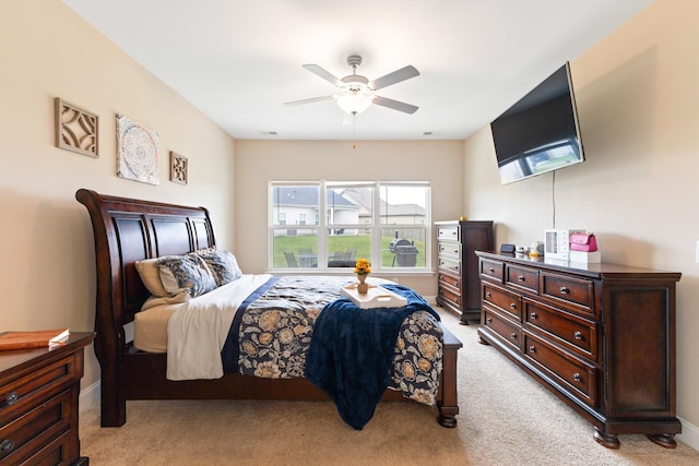 bedroom with light carpet, visible vents, baseboards, and a ceiling fan