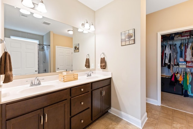 bathroom featuring double vanity, baseboards, visible vents, and a sink