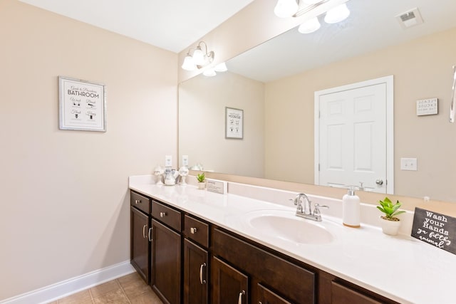 bathroom with tile patterned flooring, vanity, visible vents, and baseboards