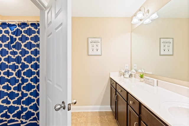 bathroom featuring curtained shower, tile patterned flooring, vanity, and baseboards