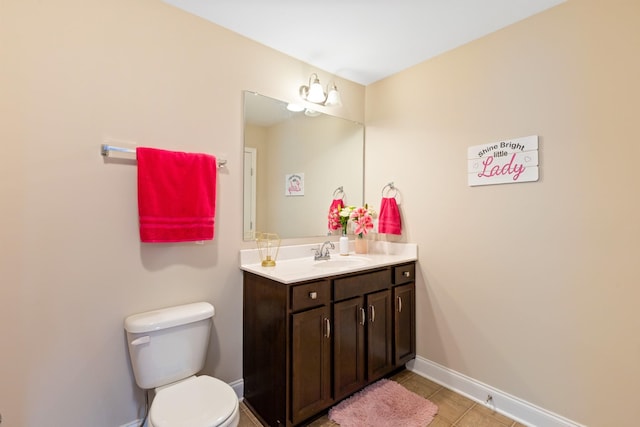 bathroom featuring baseboards, vanity, toilet, and tile patterned floors