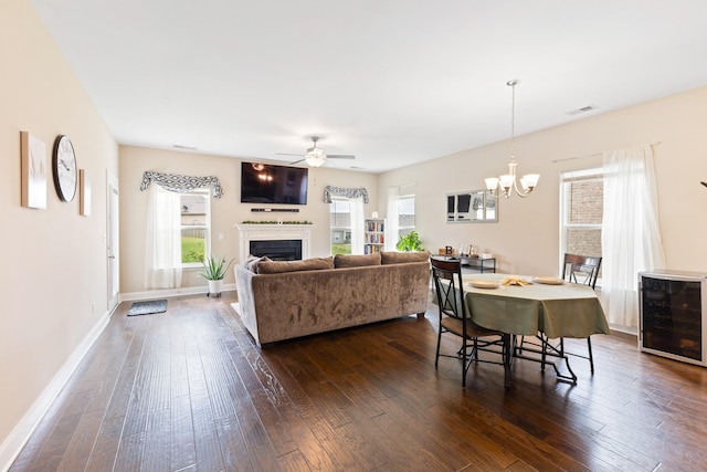 living room with wine cooler, a fireplace, visible vents, baseboards, and dark wood-style floors