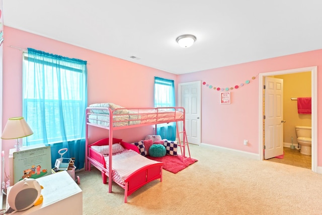 bedroom featuring carpet floors, ensuite bath, and baseboards