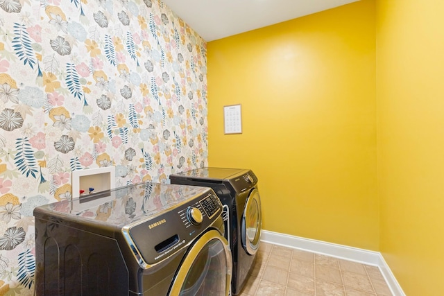 clothes washing area with laundry area, separate washer and dryer, and baseboards