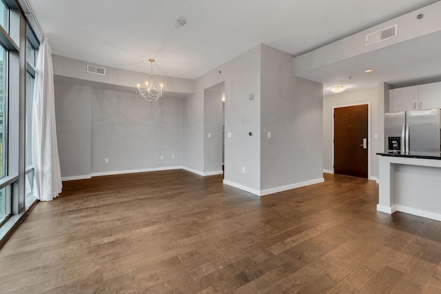 interior space featuring dark wood-style floors, plenty of natural light, visible vents, and baseboards