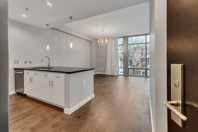 kitchen with dishwasher, dark countertops, dark wood-style flooring, floor to ceiling windows, and a sink