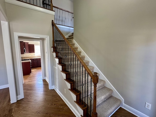 stairway with baseboards and wood finished floors