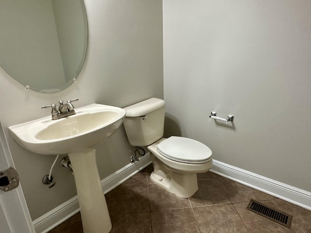 bathroom featuring toilet, tile patterned flooring, visible vents, and baseboards