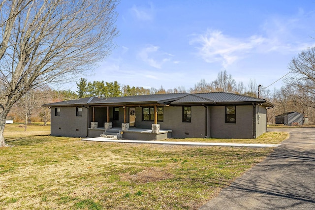 view of front of home featuring metal roof, covered porch, brick siding, crawl space, and a front lawn