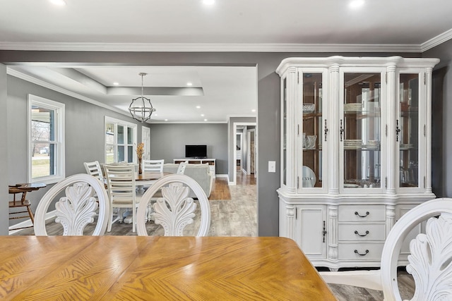 dining space with a chandelier, ornamental molding, light wood finished floors, and recessed lighting