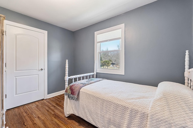 bedroom with wood finished floors and baseboards