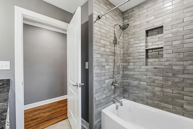 bathroom featuring tub / shower combination and baseboards