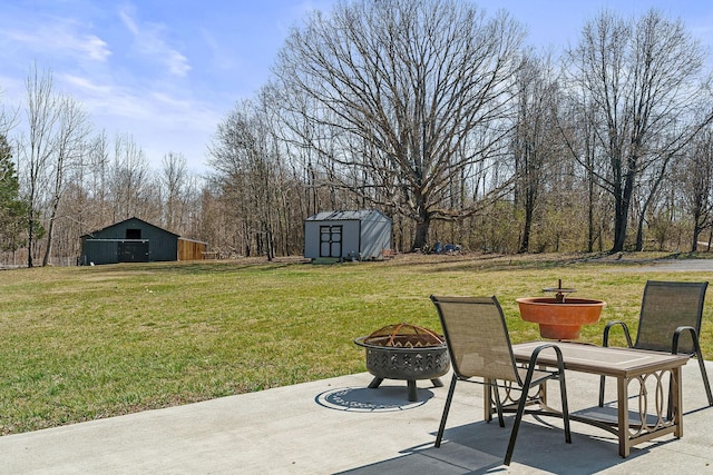 view of yard featuring an outbuilding, a patio, a fire pit, and a storage shed