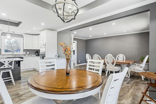 dining space with recessed lighting, a notable chandelier, and light wood finished floors