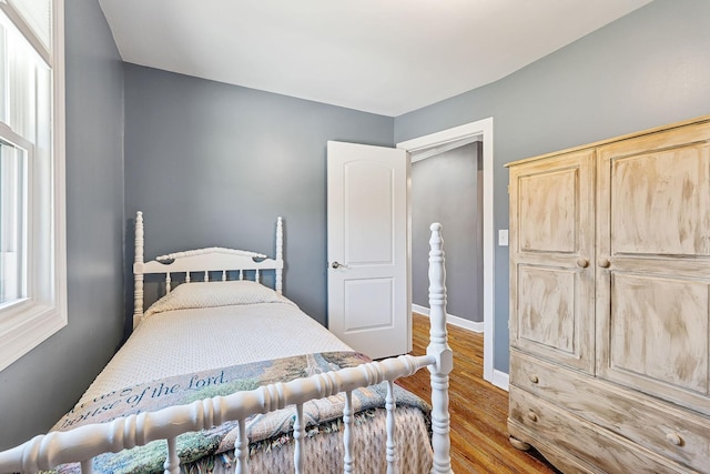 bedroom featuring baseboards and wood finished floors