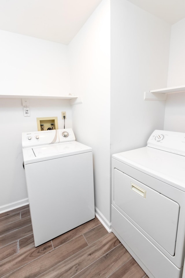 laundry room with laundry area, wood finished floors, and independent washer and dryer