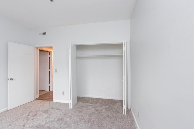 unfurnished bedroom with a closet, carpet flooring, visible vents, and baseboards