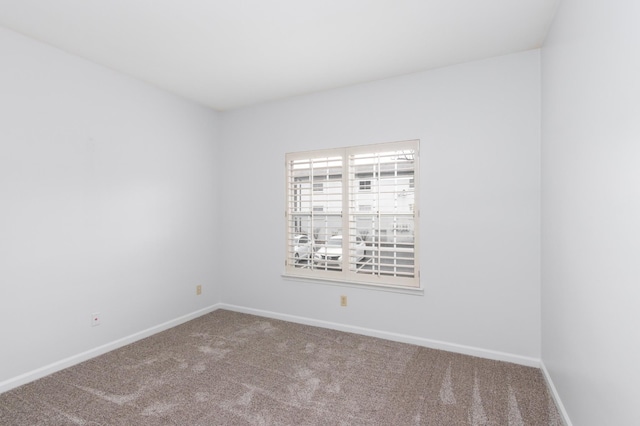 carpeted empty room with baseboards