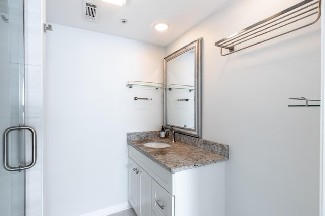 bathroom with visible vents, vanity, and a shower stall