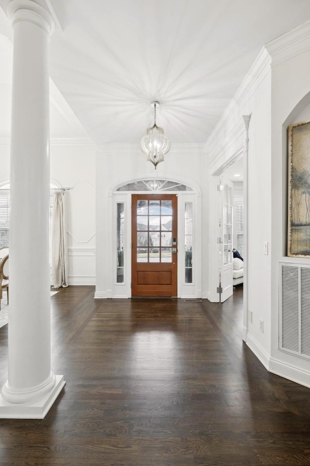 entrance foyer featuring visible vents, crown molding, ornate columns, and wood finished floors