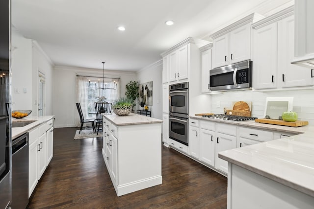 kitchen with dark wood-type flooring, stainless steel appliances, and crown molding