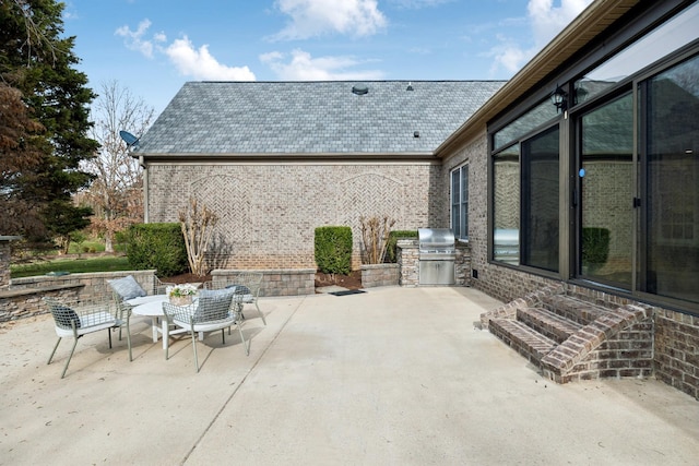 view of patio / terrace featuring outdoor dining area, an outdoor kitchen, and area for grilling