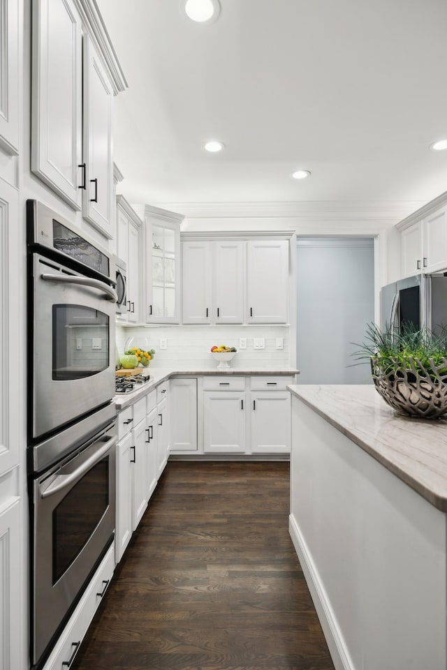 kitchen with stainless steel appliances, backsplash, white cabinets, and recessed lighting