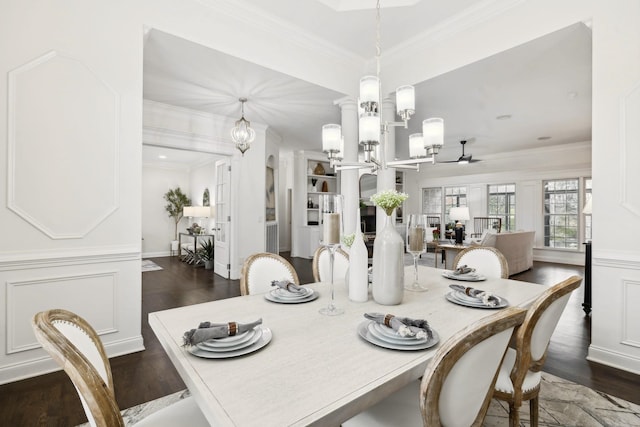 dining space featuring a decorative wall, ornamental molding, dark wood-style flooring, and an inviting chandelier