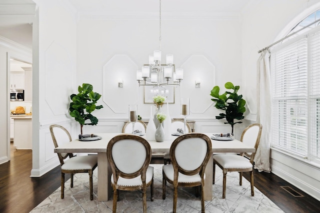 dining room with plenty of natural light, crown molding, and wood finished floors