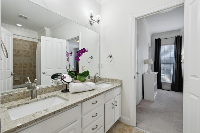 bathroom with crown molding, visible vents, a sink, and double vanity