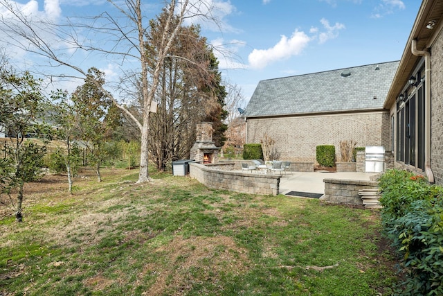 view of yard featuring a patio and an outdoor stone fireplace