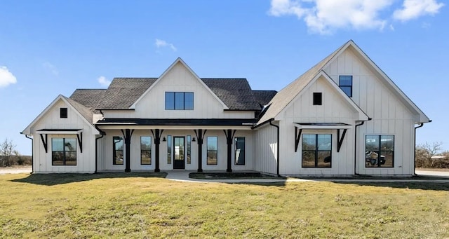 rear view of property with roof with shingles, board and batten siding, and a yard