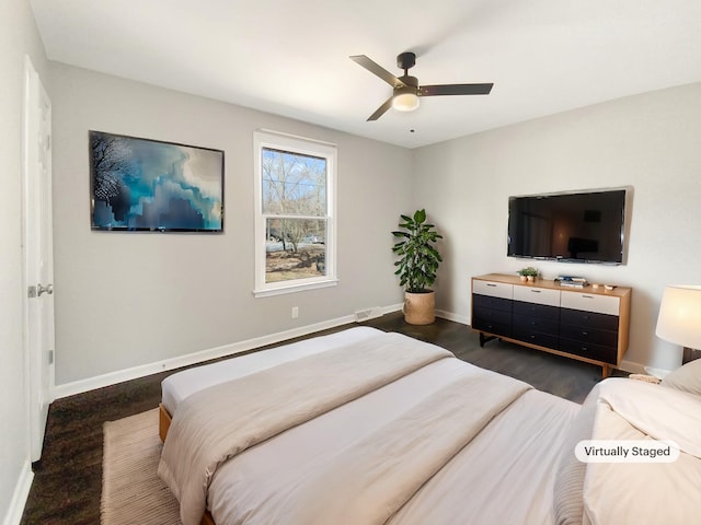 bedroom with ceiling fan, baseboards, and wood finished floors