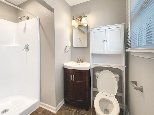 full bathroom with toilet, a stall shower, baseboards, and vanity