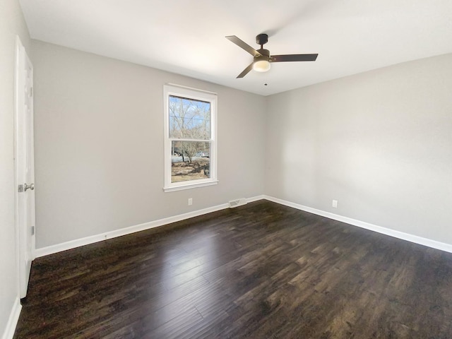 unfurnished room with ceiling fan, visible vents, baseboards, and dark wood-type flooring