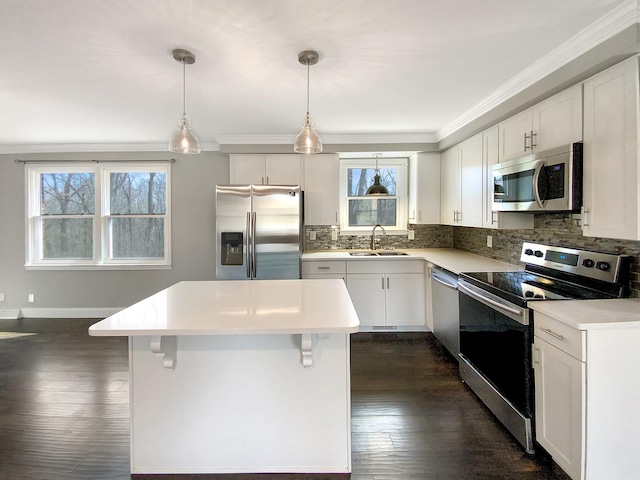 kitchen with tasteful backsplash, appliances with stainless steel finishes, dark wood-type flooring, a center island, and a sink