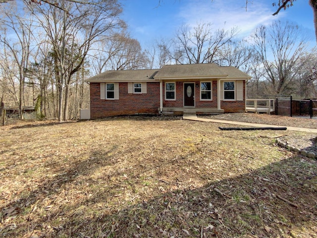 ranch-style house featuring fence and brick siding