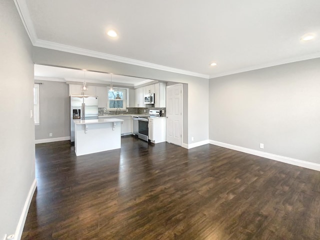 kitchen with crown molding, dark wood-style flooring, stainless steel appliances, and light countertops