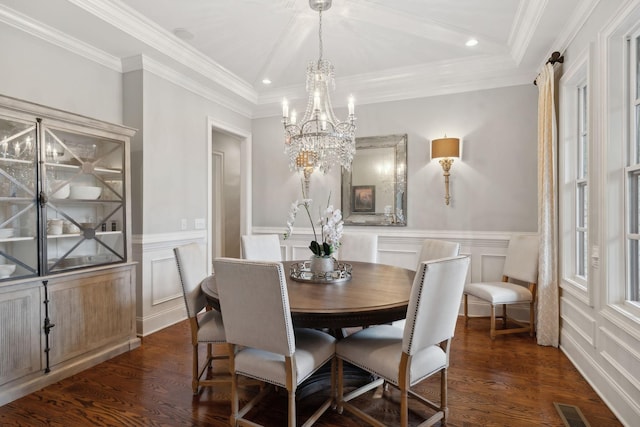 dining area with a chandelier, dark wood-type flooring, visible vents, and a decorative wall